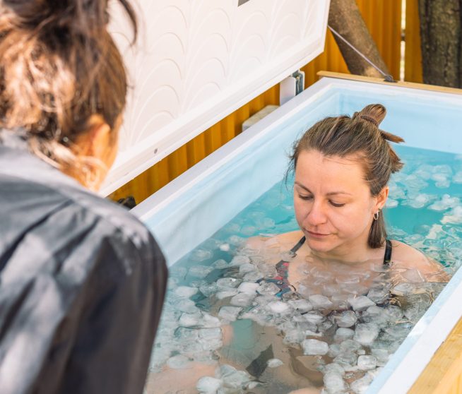 Girl or woman ice bathing in the cold water among ice cubes. Wim